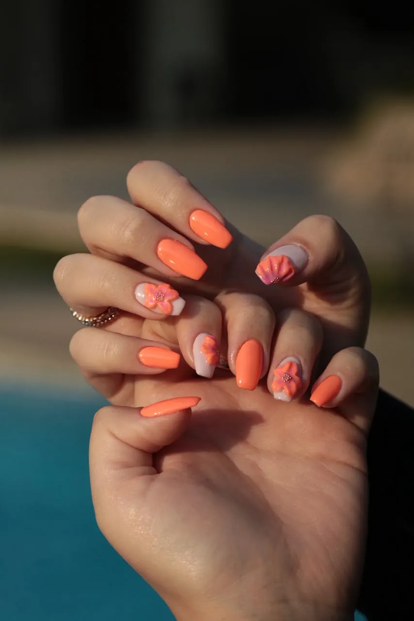 Bright orange gel nails with sculpted 3D floral detail