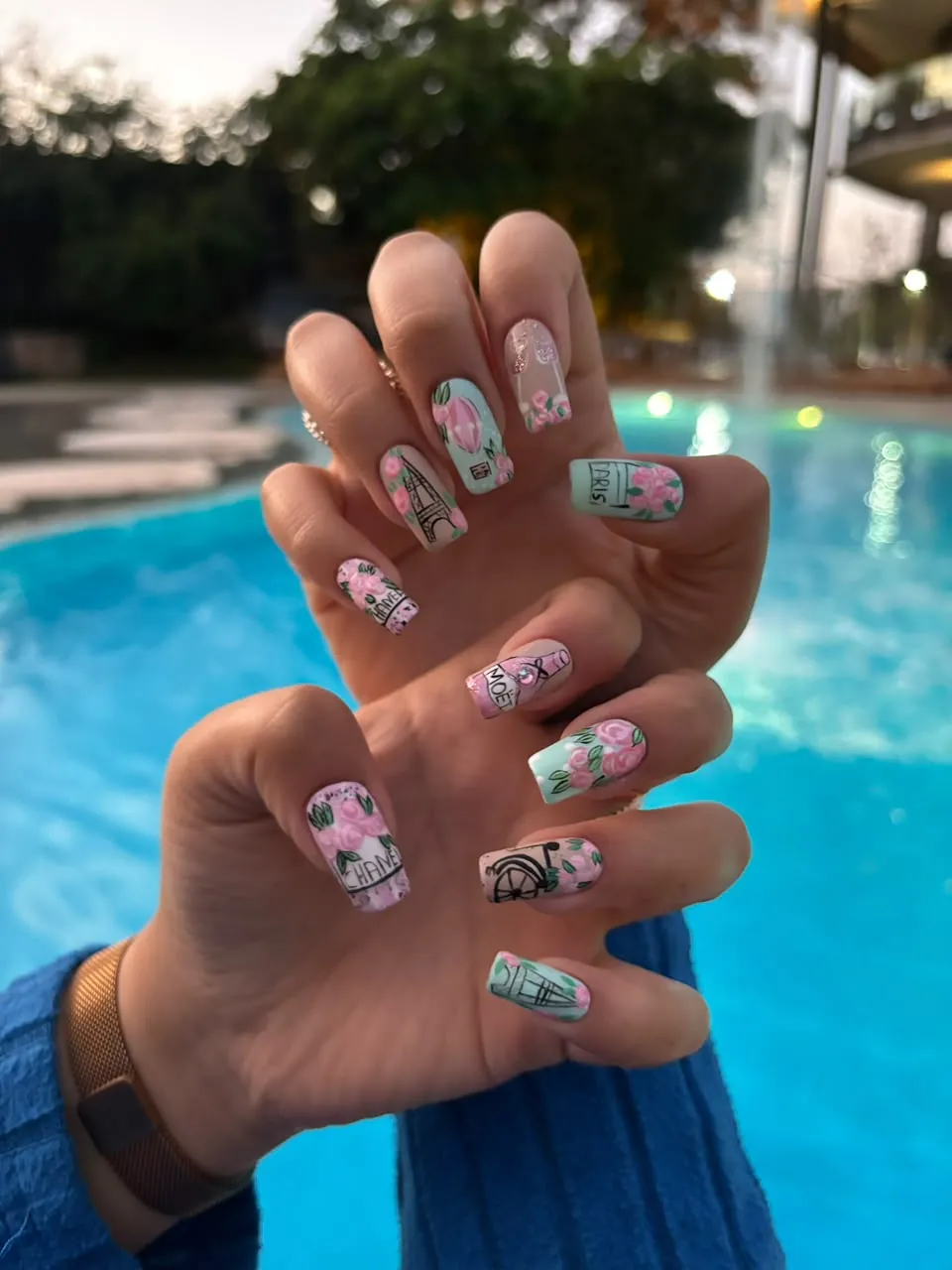 Paris-themed nail art with painted roses and fine line work
