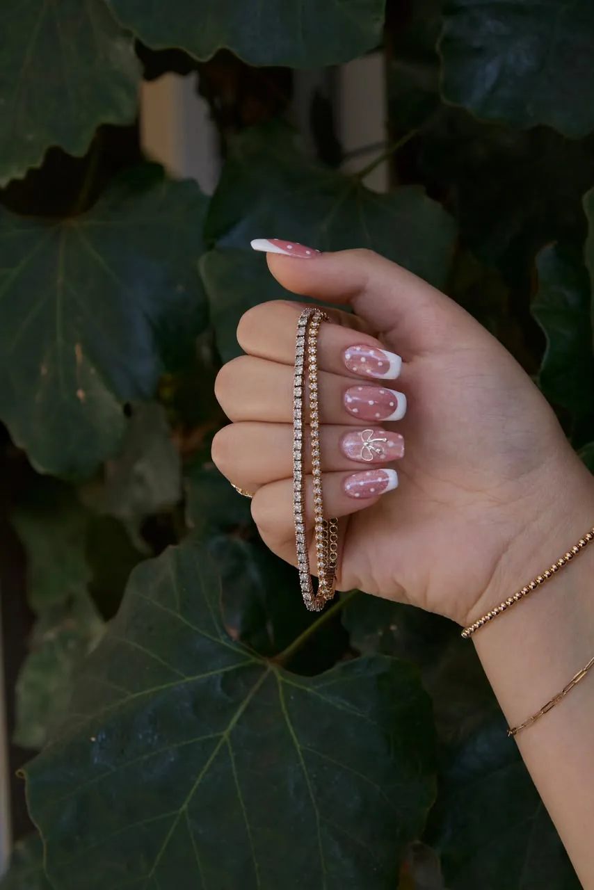 Pink polka-dot French tips finished with a small bow